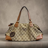Gucci Sukey handbag crafted from the brand's iconic beige and brown GG canvas with brown leather trim.