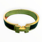 Hermès Clic H bracelet in black enamel with yellow-gold-tone hardware, with the signature “H” toggle clasp.